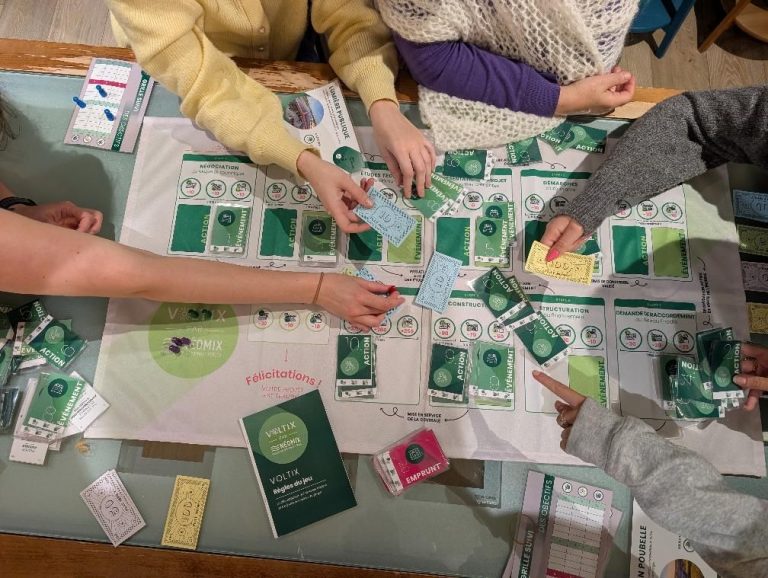 Participants testant le serious game photovoltaïque de Néomix autour d’un plateau de jeu pédagogique sur les étapes d’un projet solaire.